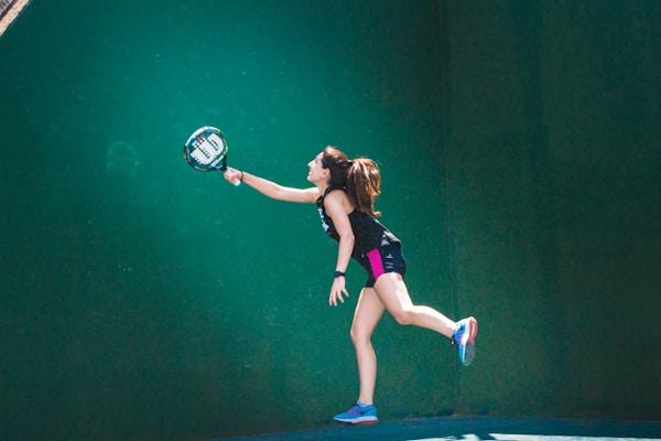 a woman holding a tennis racquet on a tennis court